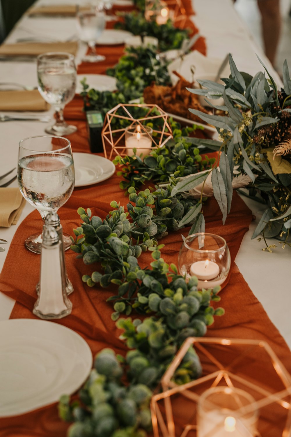 Clay and cream terracotta-toned wedding table in candlelight